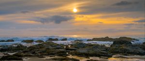 Preview wallpaper sunset, sky, stones, coast, sand