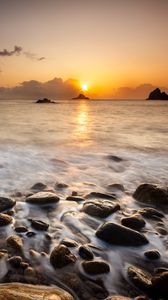 Preview wallpaper sunset, stones, pebbles, sea, horizon