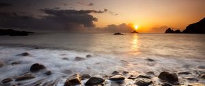 Preview wallpaper sunset, stones, pebbles, sea, horizon