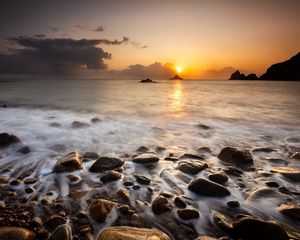 Preview wallpaper sunset, stones, pebbles, sea, horizon