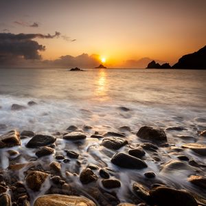 Preview wallpaper sunset, stones, pebbles, sea, horizon