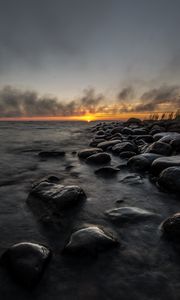 Preview wallpaper sunset, stones, sea, water, horizon, sky