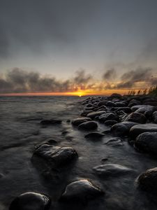 Preview wallpaper sunset, stones, sea, water, horizon, sky