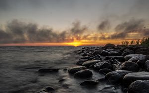 Preview wallpaper sunset, stones, sea, water, horizon, sky