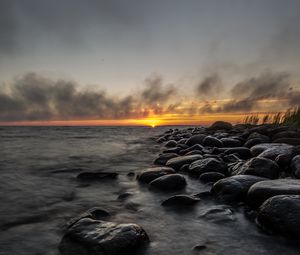 Preview wallpaper sunset, stones, sea, water, horizon, sky