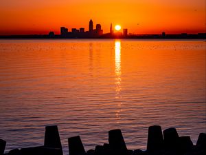 Preview wallpaper sunset, sun, city, silhouettes, water, dark