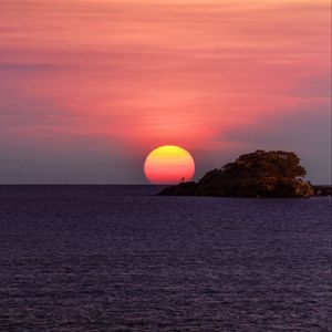 Preview wallpaper sunset, sun, horizon, rock, sea