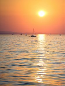 Preview wallpaper sunset, sun, ocean, boats, horizon