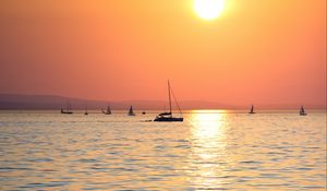 Preview wallpaper sunset, sun, ocean, boats, horizon