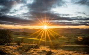 Preview wallpaper sunset, sun, rays, light, field, landscape