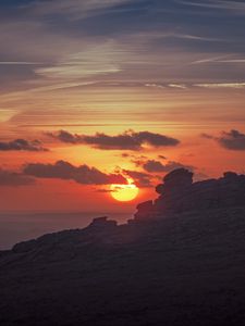 Preview wallpaper sunset, sun, rocks, stone, clouds