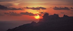 Preview wallpaper sunset, sun, rocks, stone, clouds