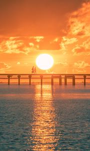 Preview wallpaper sunset, sun, silhouette, bridge, sea, glare