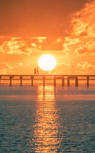 Preview wallpaper sunset, sun, silhouette, bridge, sea, glare