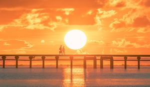 Preview wallpaper sunset, sun, silhouette, bridge, sea, glare