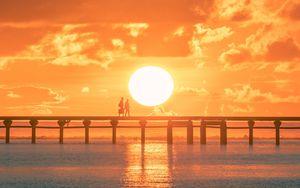 Preview wallpaper sunset, sun, silhouette, bridge, sea, glare