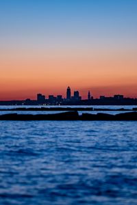 Preview wallpaper sunset, water, city, buildings, silhouettes, dark