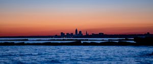 Preview wallpaper sunset, water, city, buildings, silhouettes, dark