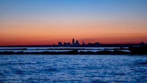 Preview wallpaper sunset, water, city, buildings, silhouettes, dark