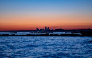 Preview wallpaper sunset, water, city, buildings, silhouettes, dark