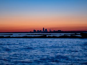 Preview wallpaper sunset, water, city, buildings, silhouettes, dark