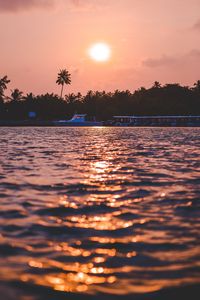 Preview wallpaper sunset, waves, water, boat, palm trees