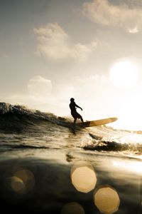 Preview wallpaper surfer, surfing, waves, sunset, glare, bokeh