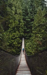 Preview wallpaper suspension bridge, man, forest, trees