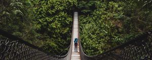 Preview wallpaper suspension bridge, man, forest, trees