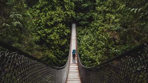 Preview wallpaper suspension bridge, man, forest, trees