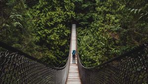 Preview wallpaper suspension bridge, man, forest, trees