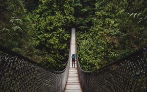 Preview wallpaper suspension bridge, man, forest, trees