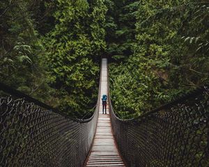 Preview wallpaper suspension bridge, man, forest, trees