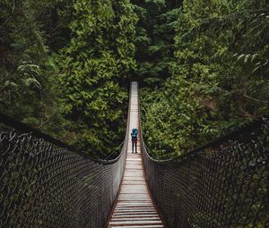 Preview wallpaper suspension bridge, man, forest, trees