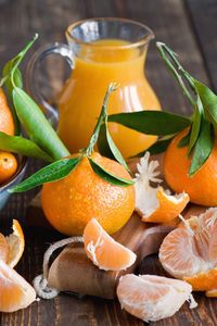 Preview wallpaper tangerines, fruit, citrus fruit, leaves, peels, cloves, juice, pitcher, decanter, board, scissors, tableware