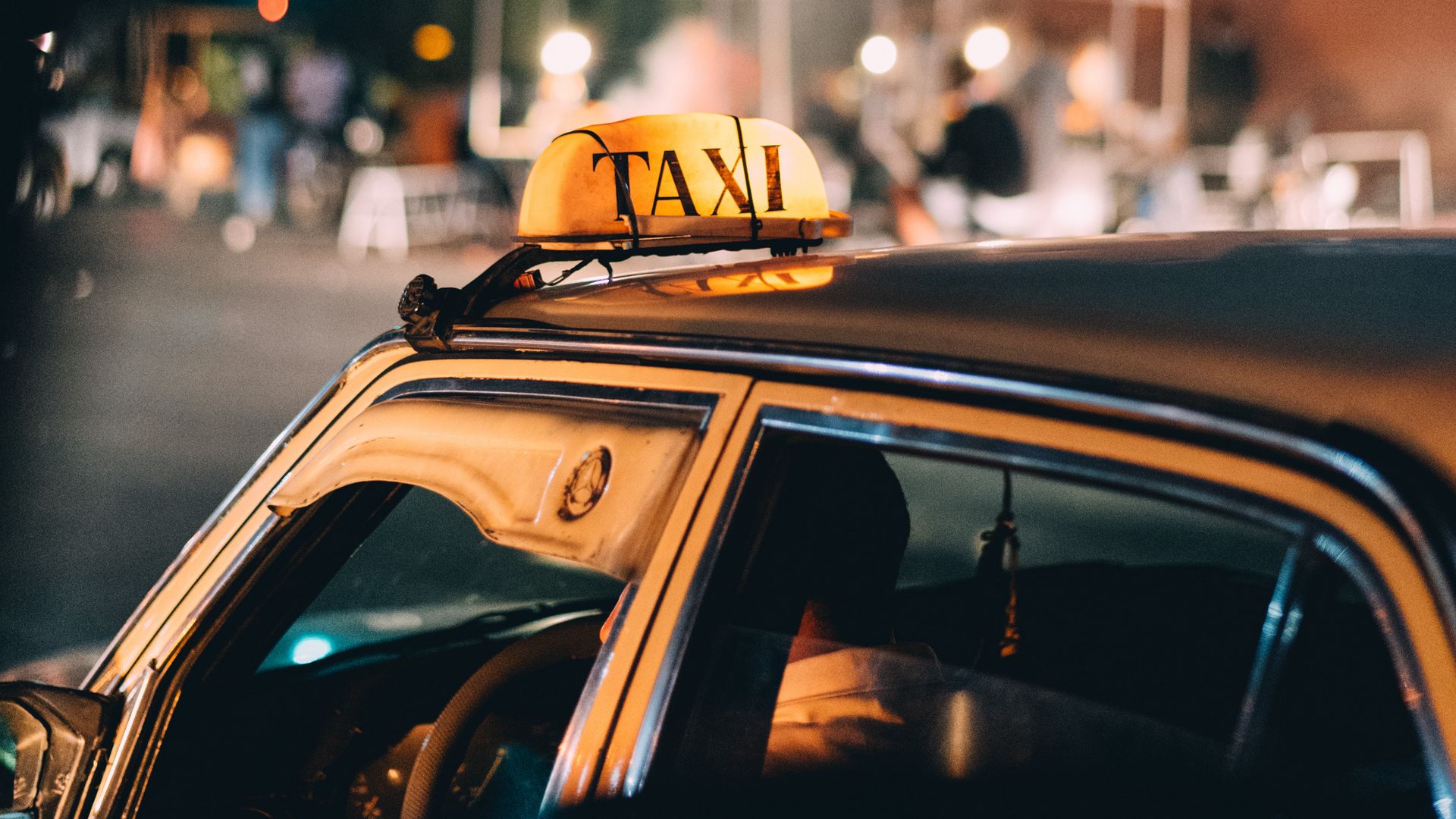 Close up of Taxi Sign and Brown Building in Background · Free Stock Photo