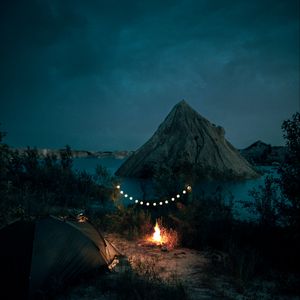 Preview wallpaper tent, camping, campfire, garland, rocks