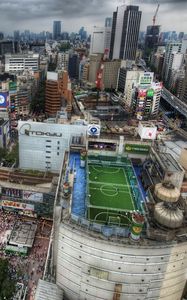Preview wallpaper tokyo, house, football, metropolis, field, people, roofs, crowds, japan, road, hdr