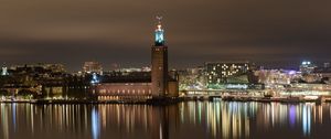 Preview wallpaper tower, buildings, lights, glow, river, night, city