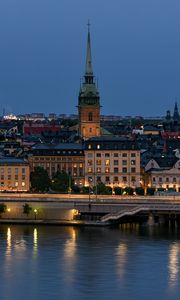 Preview wallpaper tower, buildings, lights, embankment, river, twilight