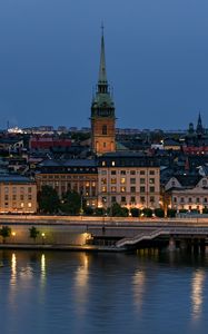 Preview wallpaper tower, buildings, lights, embankment, river, twilight