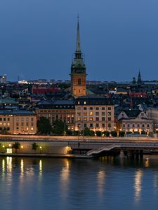 Preview wallpaper tower, buildings, lights, embankment, river, twilight