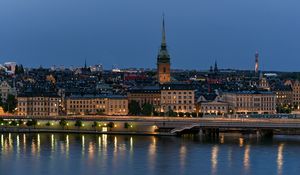 Preview wallpaper tower, buildings, lights, embankment, river, twilight