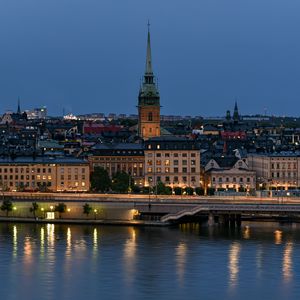 Preview wallpaper tower, buildings, lights, embankment, river, twilight