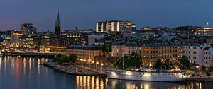 Preview wallpaper tower, buildings, lights, embankment, river, twilight, city