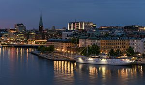 Preview wallpaper tower, buildings, lights, embankment, river, twilight, city