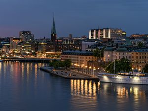 Preview wallpaper tower, buildings, lights, embankment, river, twilight, city