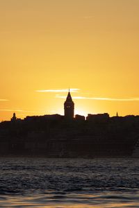Preview wallpaper tower, buildings, silhouettes, sea, sunset