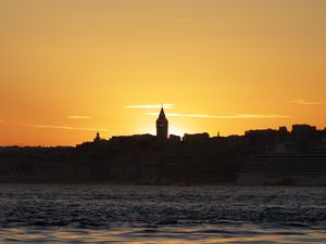 Preview wallpaper tower, buildings, silhouettes, sea, sunset