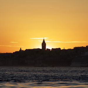Preview wallpaper tower, buildings, silhouettes, sea, sunset